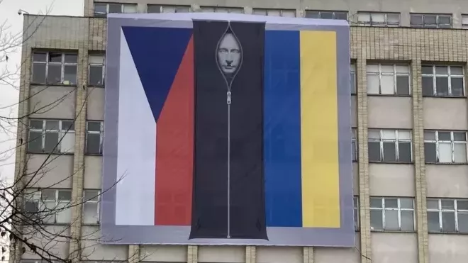Na budově ministerstva vnitra v Praze visí česká a ukrajinská vlajka, uprostřed se nachází podobizna ruského prezidenta Vladimira Putina ve vaku na mrtvoly.